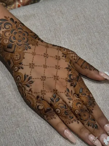 A beautiful 'jaal' or net pattern on the back of the hand, framed by a thick floral border. This design is intricate yet feels light and elegant.