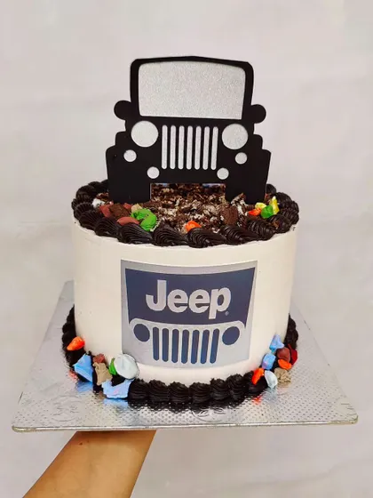 This Jeep-themed cake is perfect for an off-road adventurer. It features the Jeep logo and a silhouette topper.
