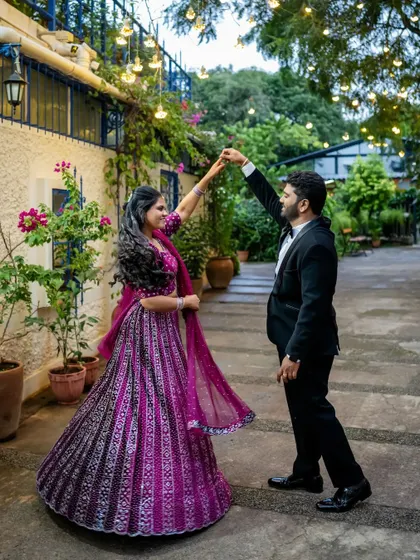 The couple shares a dance in a charming courtyard, the bride's lehenga twirling beautifully.