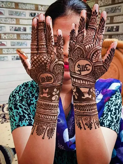 Another view of the "Aai-Baba" mehandi, showing the intricate patterns that surround the meaningful text.