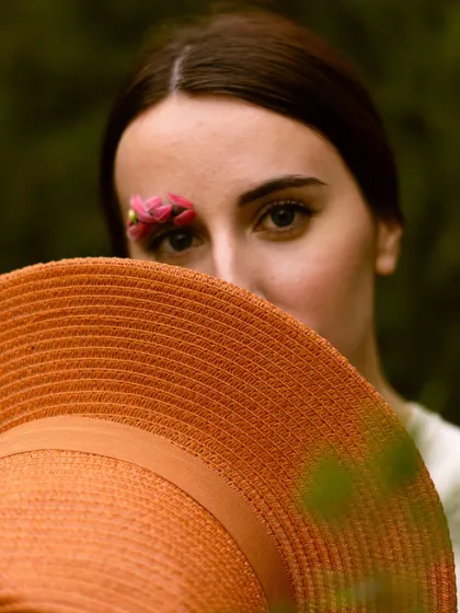 A mysterious portrait using a hat to obscure part of the face. This creates intrigue and draws the viewer's eye to the model's expressive gaze.