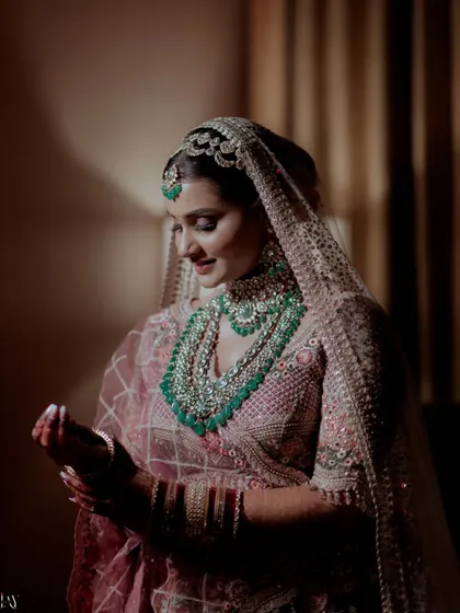 A beautifully lit portrait of the bride, her intricate green and white jewelry taking center stage.