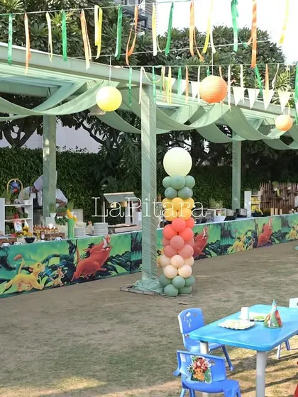 The kids' dining area at the Lion King party, with themed table runners and colorful seating.
