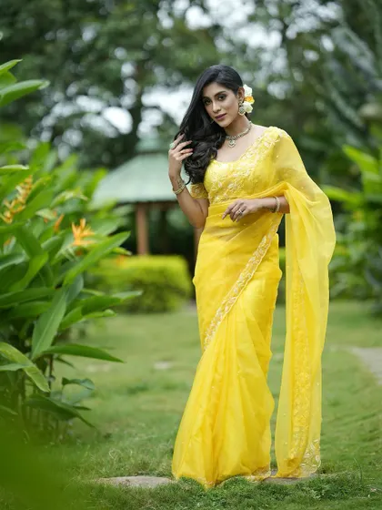 A full-length view of the yellow organza saree, showing its light and airy feel.