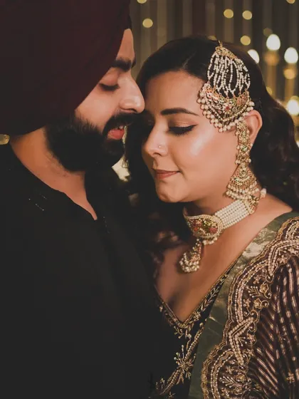 A romantic close-up of the couple. The groom's sleek indo-western outfit with monotone thread work perfectly complements her velvet ensemble.