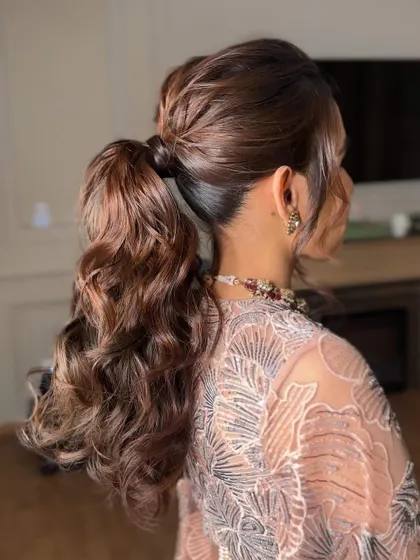 The back of the curly ponytail, showing the texture and detail of the curls. I use extensions to create this full, luscious look.
