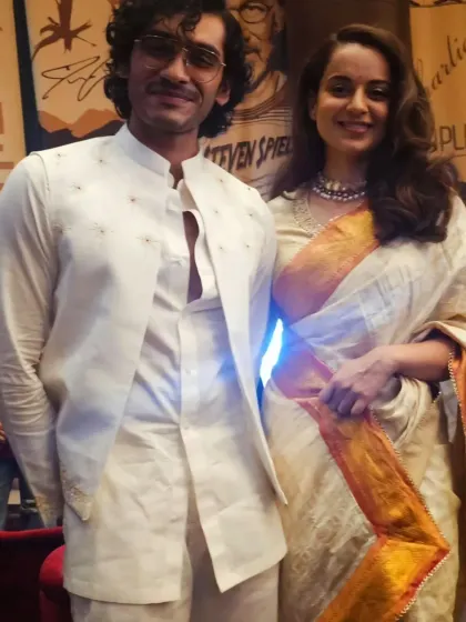 Vishak Nair and Kangana Ranaut at the premiere. This photo shows how the styled outfit looks in a public setting, interacting with other personalities and press.