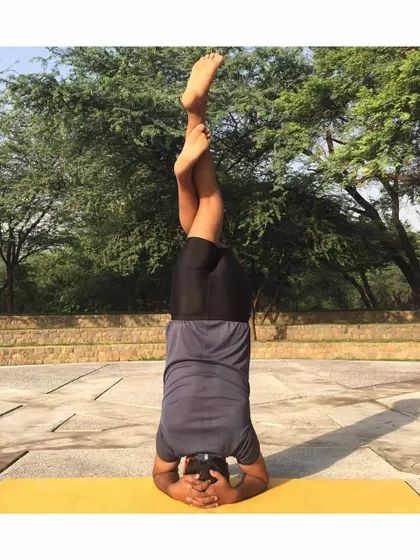 Garudasana (Eagle Pose) legs in Sirsasana (Headstand) is an advanced variation that requires immense focus and control. It combines the benefits of an inversion with a deep stretch for the hips and thighs.