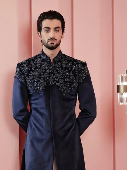 A full-length view of the navy velvet jacket, a piece that combines rich tones and intricate threadwork for a truly sophisticated look.