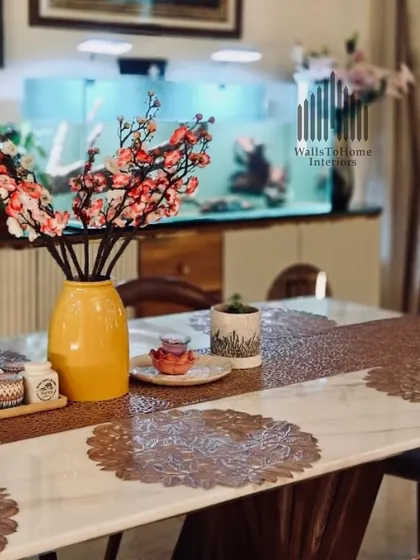 A view of the dining area, with the custom aquarium console in the background. The floral arrangement adds a pop of color, complementing the sophisticated decor.