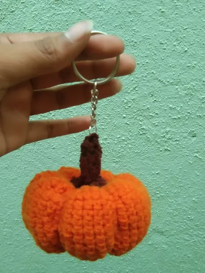 A spooky-cute pumpkin amigurumi keychain, perfect for Halloween or any autumn lover.