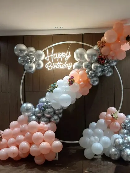 A full view of the pastel and silver balloon arch, showing how it creates a perfect photo corner for any celebration.