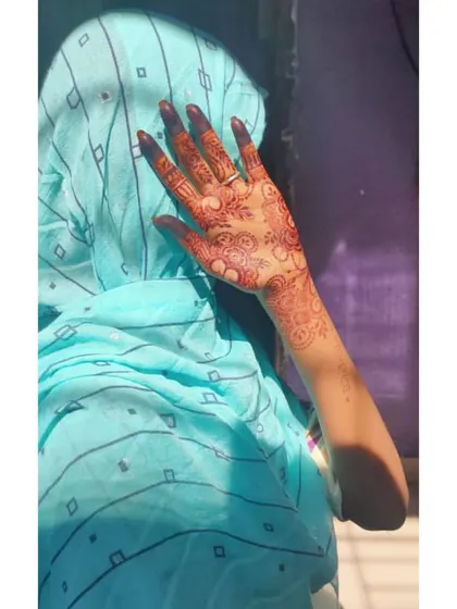 The sunlight catches this beautiful mature henna stain, showing its true reddish-brown tones. This is a classic party design with paisleys and florals covering the back of the hand.