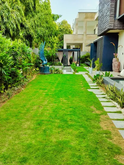 The expansive lawn provides a sense of openness, while the surrounding trees and hedges create a feeling of seclusion.
