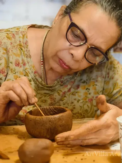 An older participant meticulously adds details to her bowl. Our workshops are welcoming and accessible to art lovers of all ages.