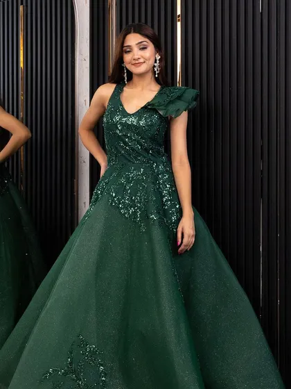 A full-length shot of the emerald green gown, showing its beautiful A-line silhouette and one-shoulder ruffle detail.