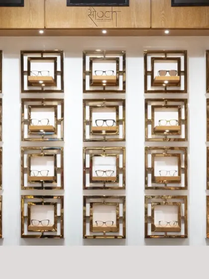 The wall display features individual frames made of wood and brass, creating a unique and artistic way to showcase premium eyewear.