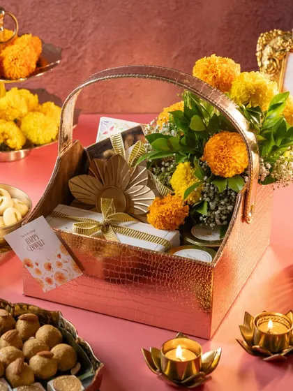 An elegant Diwali hamper featuring a floral arrangement, our dessert boxes, and traditional diyas. I love creating custom bulk gifting solutions for the festive season.