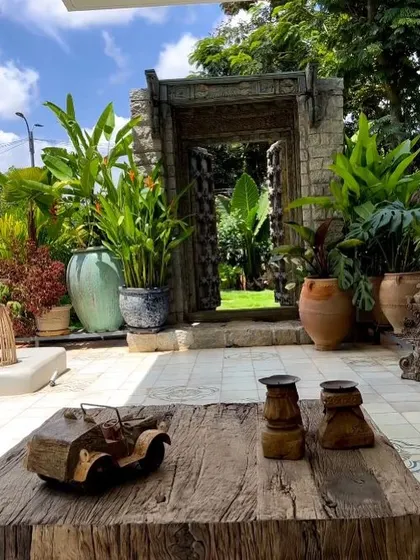 An artistic backyard patio featuring a rustic wooden coffee table and terracotta pots, with the antique door providing a beautiful backdrop. This space is a testament to blending art, decor, and nature.