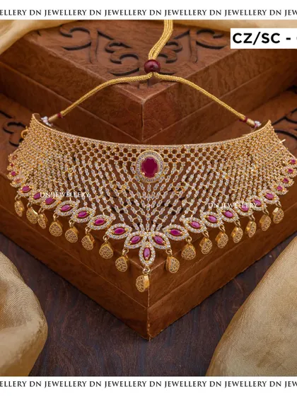 This gold-plated CZ choker with a central ruby stone is a beautiful fusion of modern and traditional styles. The lattice design is very unique.