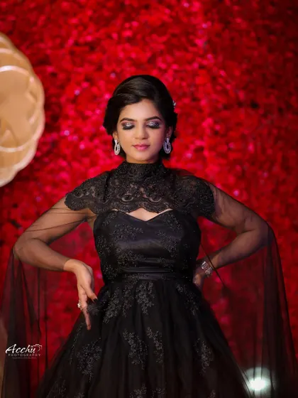 This pose with closed eyes feels serene and artistic. It’s a beautiful, quiet moment captured amidst the drama of the red background and the elegant black gown.