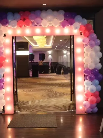 A view from the other side of the illuminated arch, showing how it frames the entrance to the event space. We used a different color scheme of purple, pink, and white for this event.