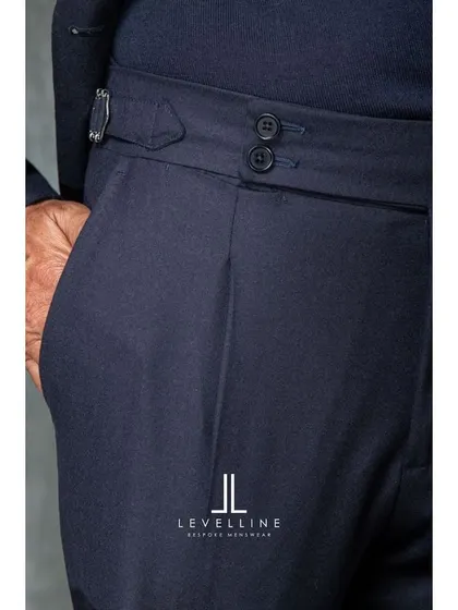 The details of our bespoke trousers, including pleated fronts and side adjusters. These elements not only add style but also enhance comfort and movement.