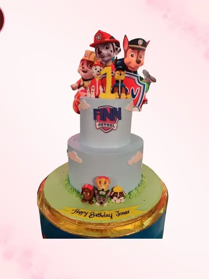A two-tiered Paw Patrol cake for a first birthday. The design includes the iconic lookout tower and several members of the puppy rescue team.