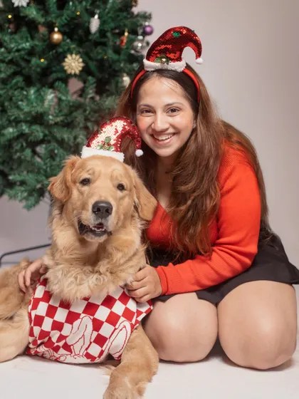 A classic Christmas portrait of a Golden Retriever and his owner sharing a festive moment by the tree. These photos capture the warmth and magic of the holiday season.