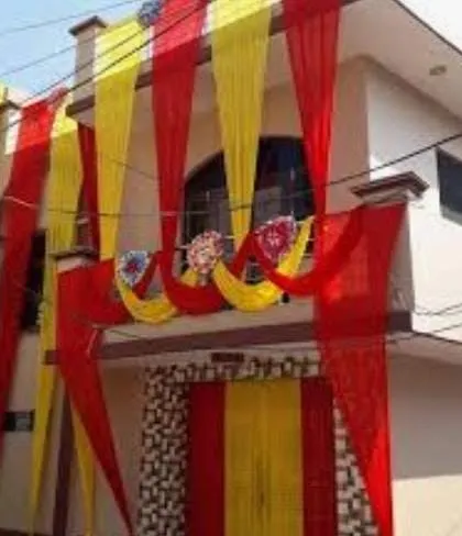A traditional house decoration using red and yellow drapes for a classic wedding look.
