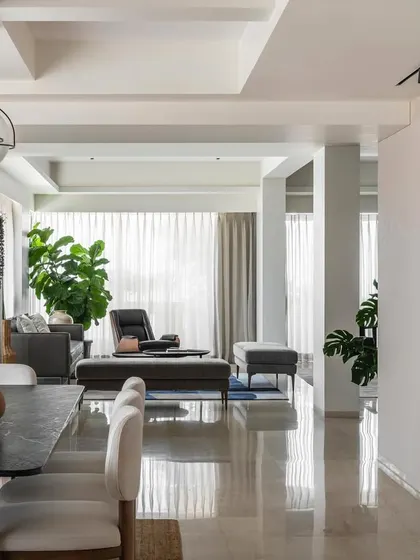 An overall view of the open-plan living and dining area in Apartment 1600, showing the polished marble floors and mid-century modern furniture.