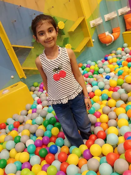 A happy visitor posing for a photo in our ball pit. It's a picture-perfect spot for fun memories.