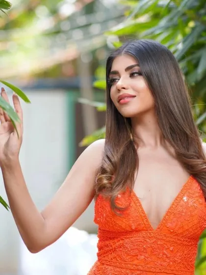A candid moment in the orange gown, showing how effortlessly beautiful it looks in a natural, outdoor setting.