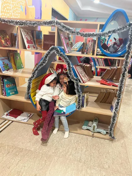 Finding a cozy nook to read a Christmas story. Our library space is designed to be inviting, encouraging kids to explore books together.