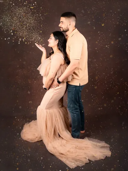 Let's celebrate your journey together. This couple's maternity portrait captures the shared excitement and love, with a touch of magic from the blowing glitter. It’s a fun, dynamic shot that freezes a moment of pure joy.