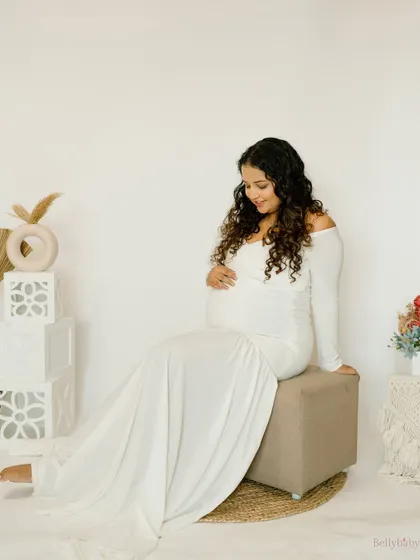 A serene and angelic portrait in a flowing white gown. The soft, clean look of this studio setup is perfect for capturing the purity of this special time.