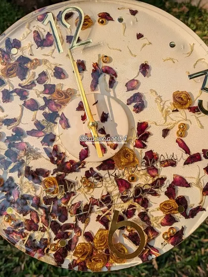 This 12-inch wall clock is filled with preserved red and gold-dusted rose petals from a wedding varmala, creating a rich and romantic timepiece.