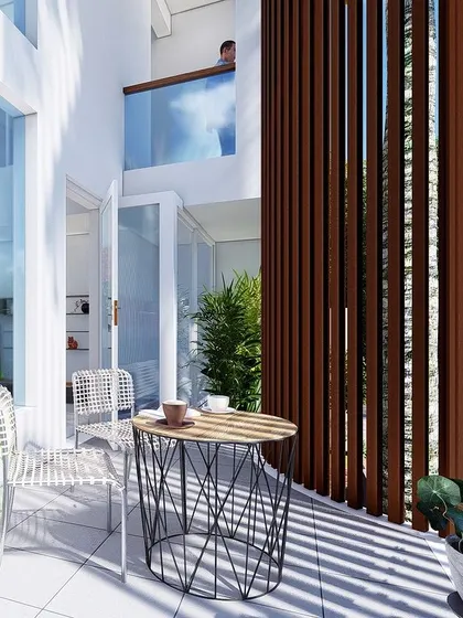 A private balcony sit-out area, shielded by vertical fins for privacy and sun protection. This small space becomes a perfect spot for a morning coffee, seamlessly connected to the interior.