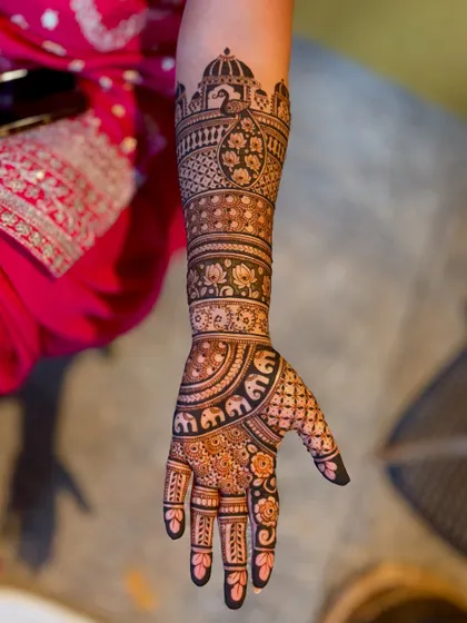 A close-up of the arm, showing the detailed drawing of the peacock and the architectural border.