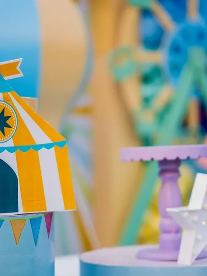 A miniature circus tent prop sits atop a display stand, adding a charming and detailed touch to the cake table area. No detail is too small to be themed.