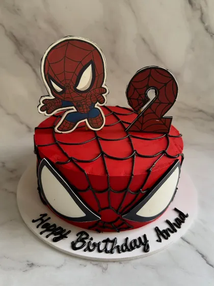 Your friendly neighborhood Spider-Man, in cake form! This design captures the iconic superhero with a web-covered red base, big spider eyes, and a cute chibi-style topper for a 2nd birthday.