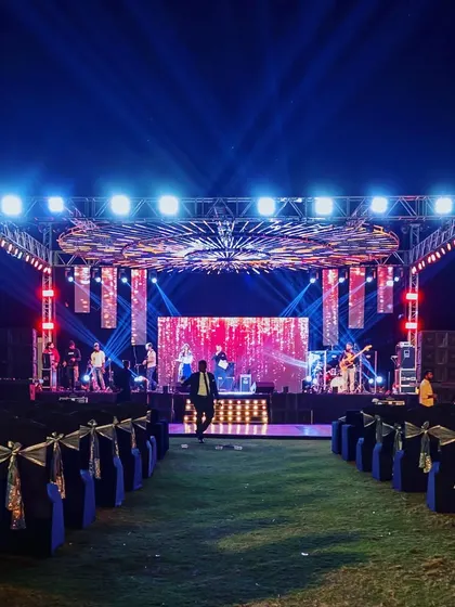 A wide shot of a massive, concert-style Sangeet stage, fully rigged with lights and LED screens, ready for a night of spectacular performances.