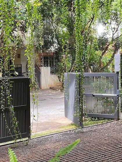 A view from the carport looking towards the entrance. The cascading vines from the first-floor planter create a living green curtain that offers privacy and beauty.