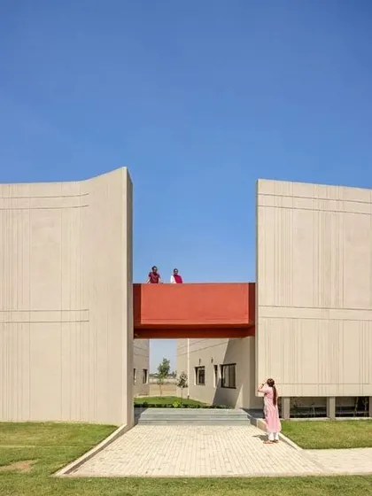 The architecture here is doing a job. These large, fortress-like walls at the SMBV school are shaped to manage Punjab's strong winds and intense sun, while the red bridge creates a pop of color and connection.