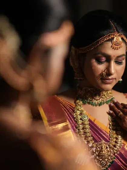 A candid moment of the bride, looking serene and beautiful. The antique gold jewellery provides a warm glow that enhances her features.