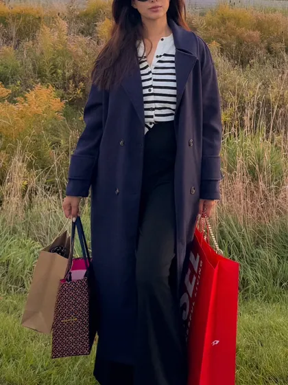 A close-up of my layered fall outfit, with a striped cardigan under a trench coat.