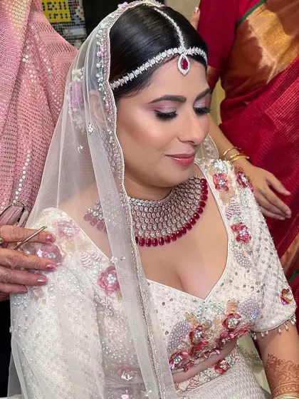 A candid moment showing the bride's soft and elegant makeup. The look is fresh and radiant, perfect for a daytime wedding ceremony.