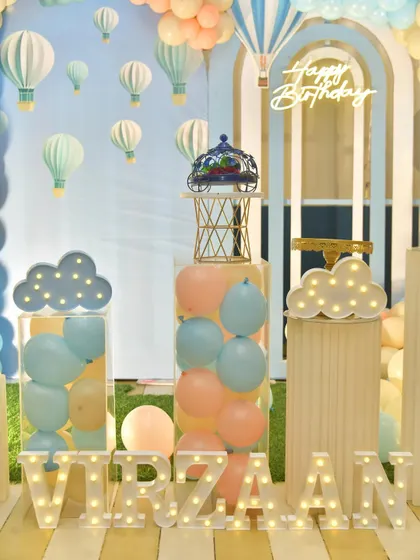 A closer look at the themed props, including light-up clouds and transparent pedestals filled with balloons.