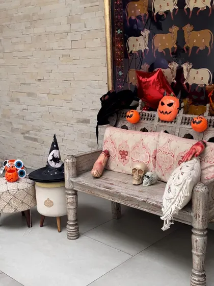 A spooky seating area at a Halloween party. A rustic bench is decorated with skulls, severed limbs, and other ghoulish props, creating a fun and frightening photo spot.