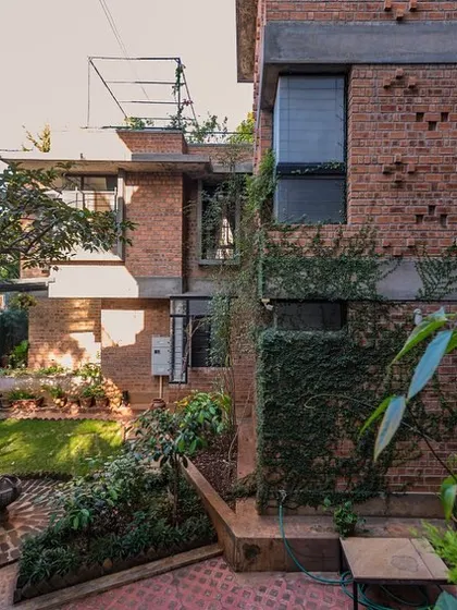 A view into the lush private garden of the Swasti residence. The home is designed around this green space, with large windows and openings that frame the garden and bring nature indoors.